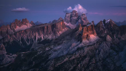 HD desktop wallpaper showcasing the majestic Dolomites in the Italian Alps, capturing rugged mountain peaks bathed in soft twilight hues.