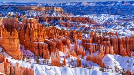 Snow-covered red rock formations at Bryce Canyon National Park, Utah, showcasing a striking winter landscape in the USA.
