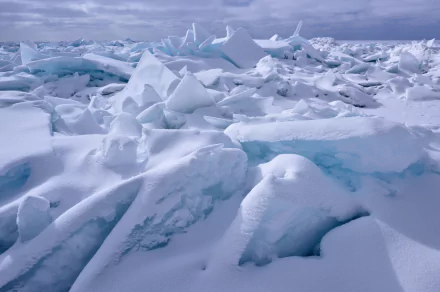 HD PC desktop wallpaper showcasing a winter landscape of snow-covered ice floes under a cloudy sky, capturing the serene and cold beauty of nature.