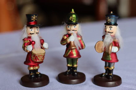 Three Christmas nutcracker figurine ornaments in red and green, one holding a drum and one cymbals, presented as a 4K Ultra HD PC desktop wallpaper background for holiday decor.
