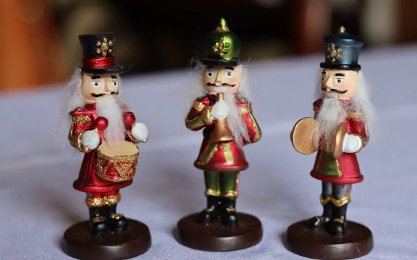 Three Christmas nutcracker figurine ornaments in red and green, one holding a drum and one cymbals, presented as a 4K Ultra HD PC desktop wallpaper background for holiday decor.