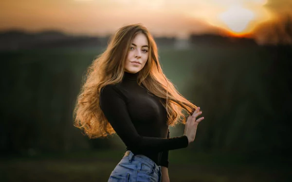 Portrait of a redhead woman model wearing makeup and jeans, set against a blurred outdoor background at sunset, captured in HD for a PC desktop wallpaper.