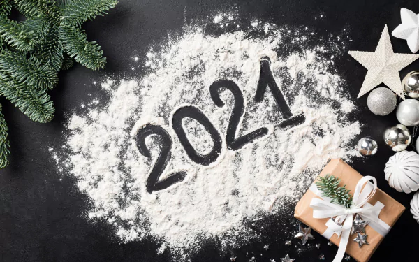 HD PC desktop wallpaper: 2021 written in flour/snow on a black surface, surrounded by fir sprigs, silver baubles, star ornaments and a wrapped gift — holiday New Year 2021.