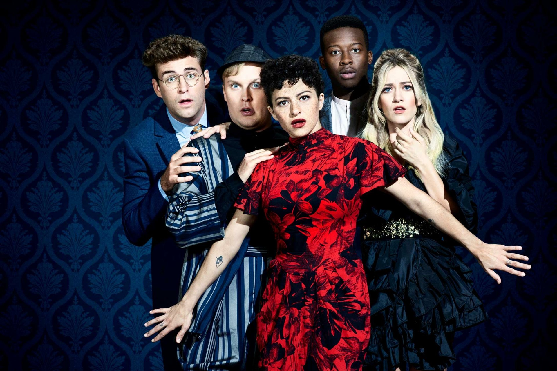A striking HD desktop wallpaper from the TV show Search Party, featuring the main characters in dramatic poses against a deep blue backdrop.