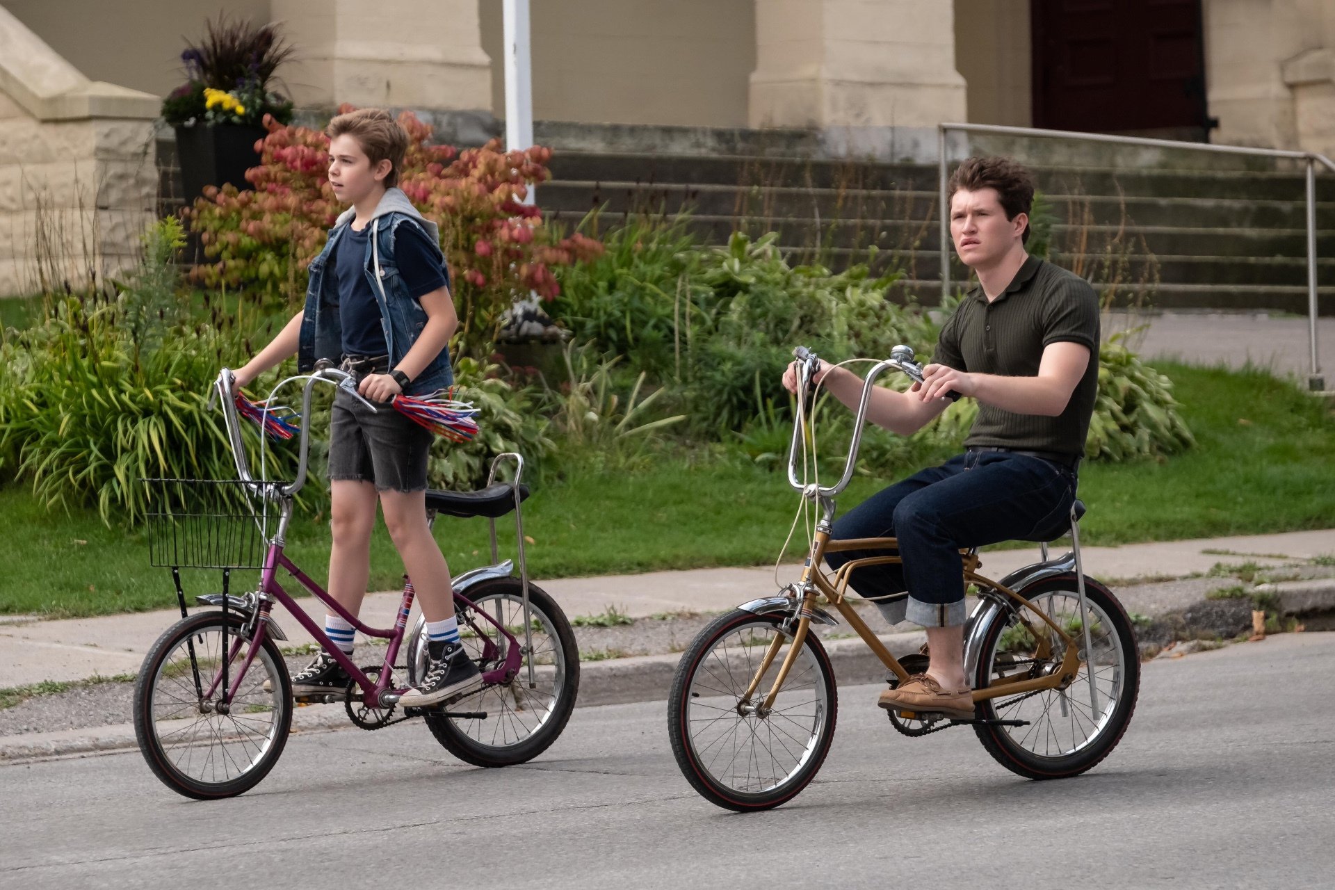 HD wallpaper featuring two individuals from The Hardy Boys riding bicycles on a suburban street.