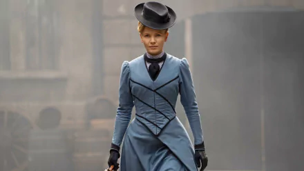 HD desktop wallpaper of a character from Miss Scarlet and the Duke in a Victorian outfit against a hazy city backdrop.