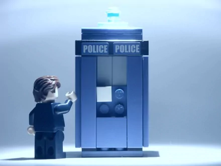 Man-made LEGO scene: minifigure approaches a blue police box against a cool-toned backdrop — 2K Quad HD PC desktop wallpaper and background.