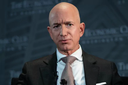 HD desktop wallpaper featuring a man in a suit with a striped tie speaking at an event, tagged as Jeff Bezos.