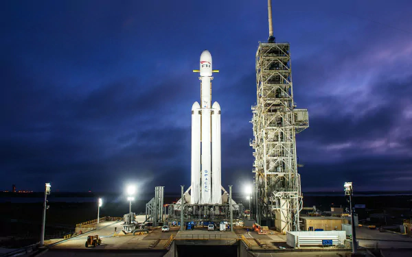 HD wallpaper of SpaceX's Falcon Heavy rocket at the launch pad during twilight.
