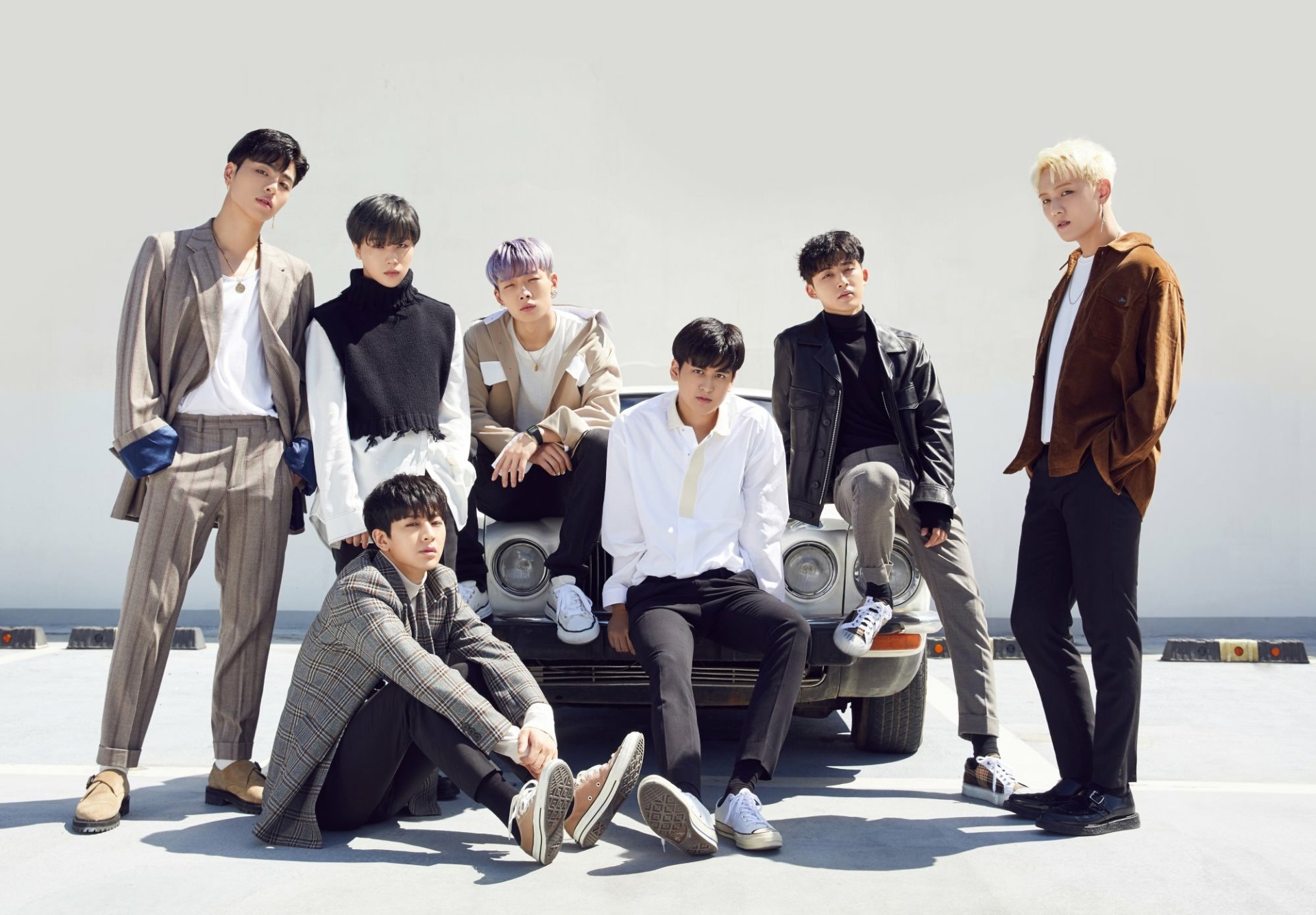 HD desktop wallpaper featuring the K-pop group iKON, with members posing stylishly beside a vintage car under a clear sky.