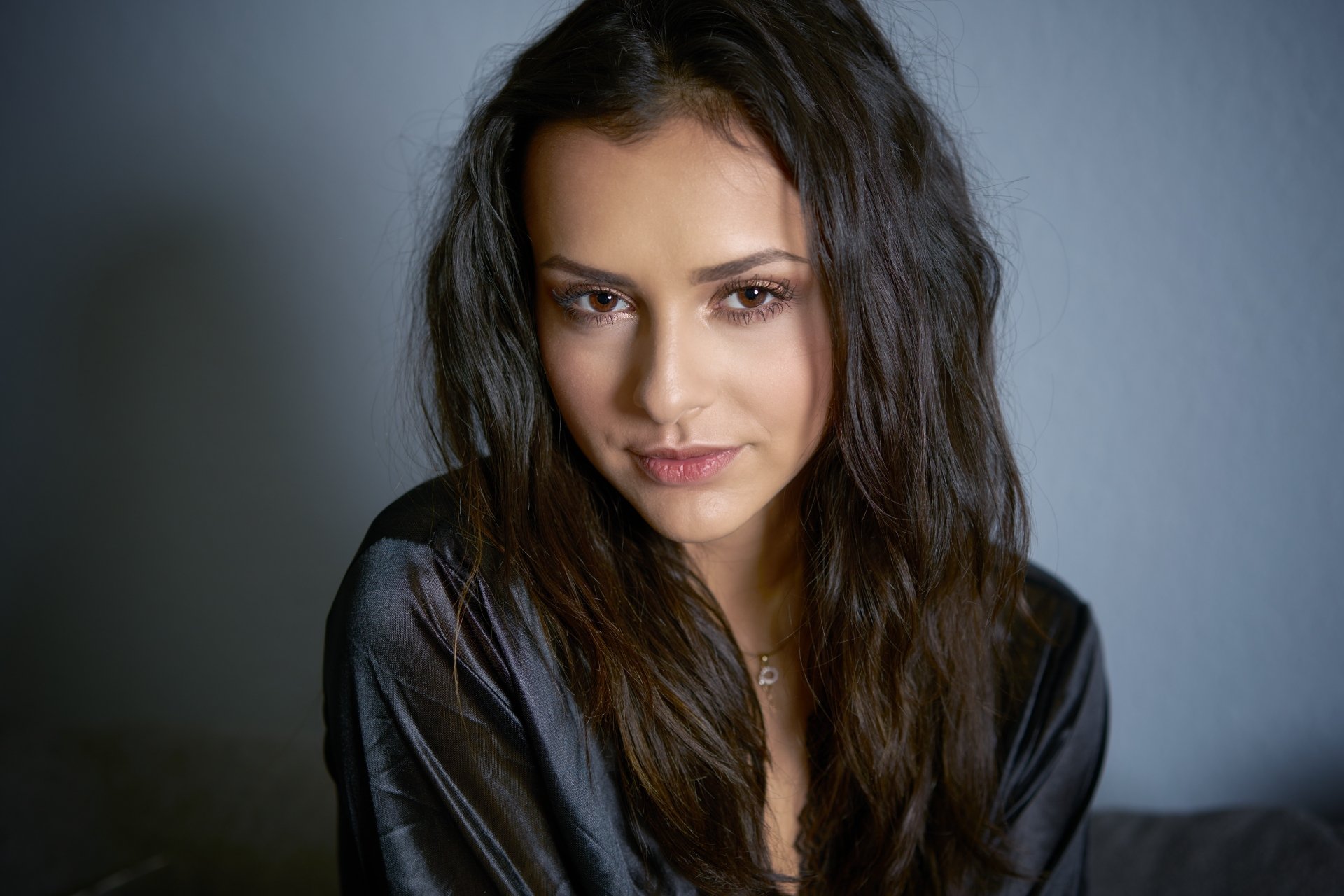 4K Ultra HD PC desktop wallpaper and background of a black‑haired woman model with brown eyes, soft wavy hair, wearing a dark silk top against a muted gray backdrop.