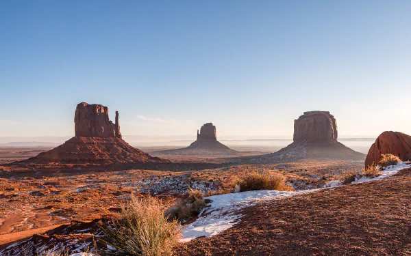 4K Ultra HD image of Monument Valley’s iconic desert rock formations under a clear blue sky, showcasing vast natural beauty in high detail.
