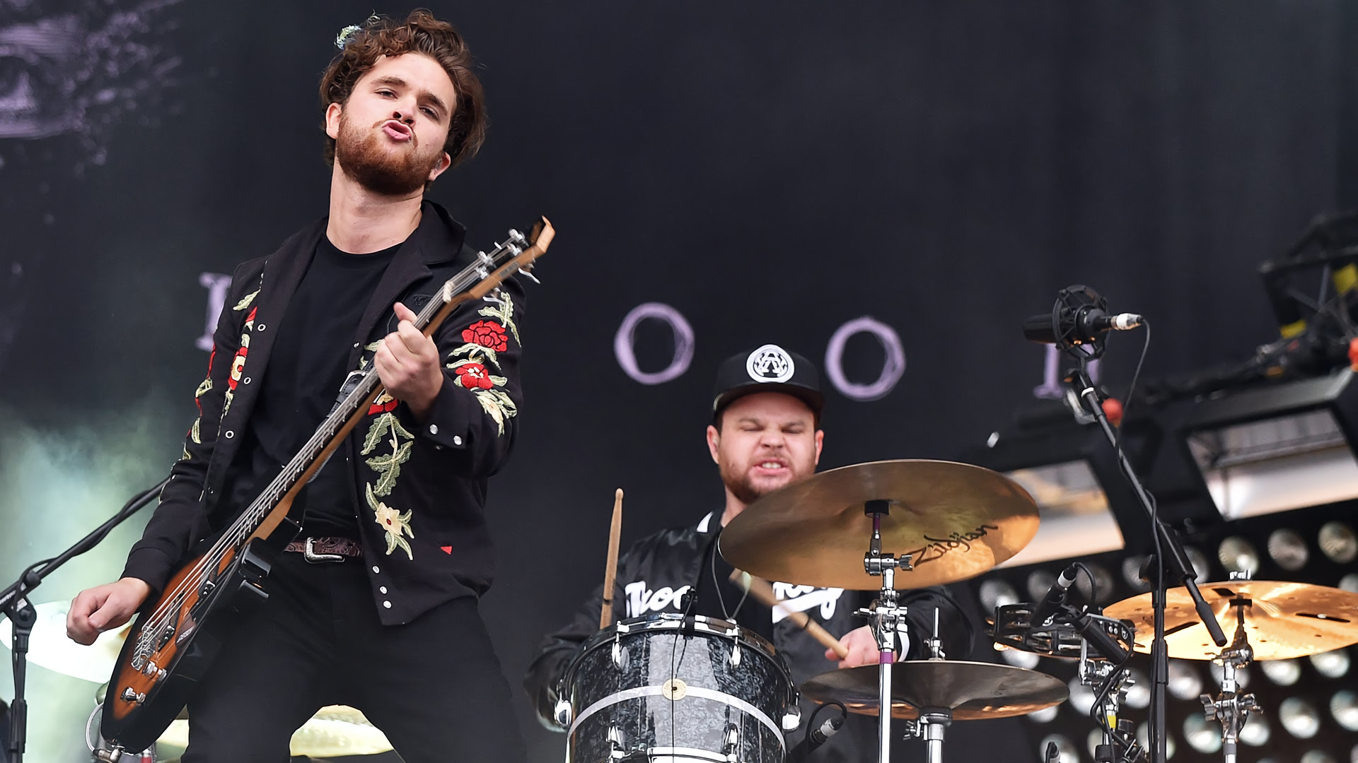 HD desktop wallpaper featuring Royal Blood band members performing live, with the guitarist in the foreground and the drummer in the background.