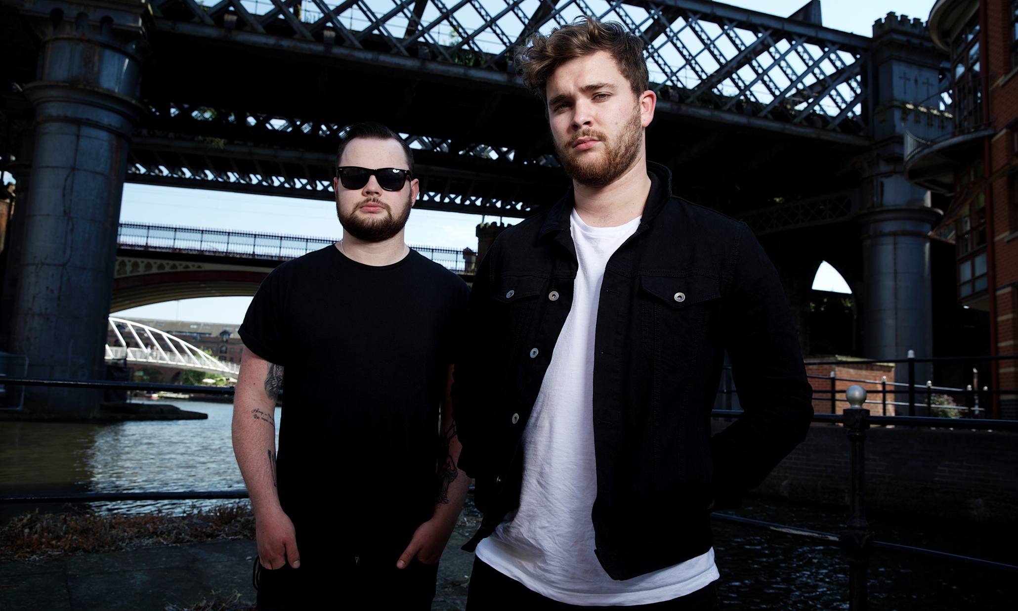 HD wallpaper featuring two members of the band styled for the 'Royal Blood' theme, posing confidently in front of an urban bridge.