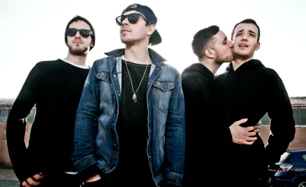 Four trendy individuals posing confidently, making a stylish HD desktop wallpaper for architects with a clear sky backdrop.