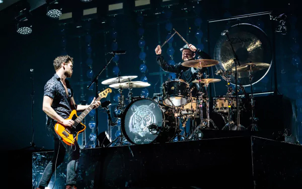 HD desktop wallpaper featuring two members of Royal Blood performing live on stage, with one playing the guitar and the other on drums, set against a dark concert backdrop.