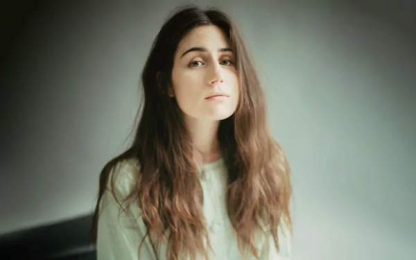 Woman with long brown hair in a contemplative pose against a soft background - dodie themed HD desktop wallpaper.