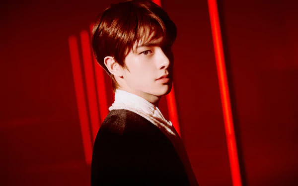 5K Ultra HD PC music wallpaper inspired by ENHYPEN: portrait of a young man in a white-collar shirt and dark jacket, dramatic red lighting and vertical neon bars in the background.