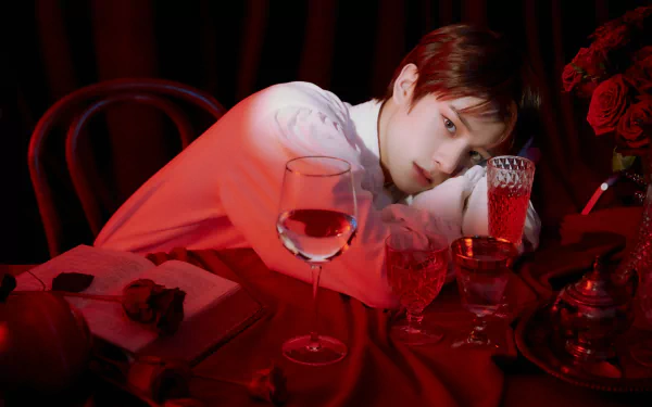 5K Ultra HD PC desktop wallpaper, music (tagged ENHYPEN): moody red-lit portrait of a person leaning on a table with a wine glass and roses.