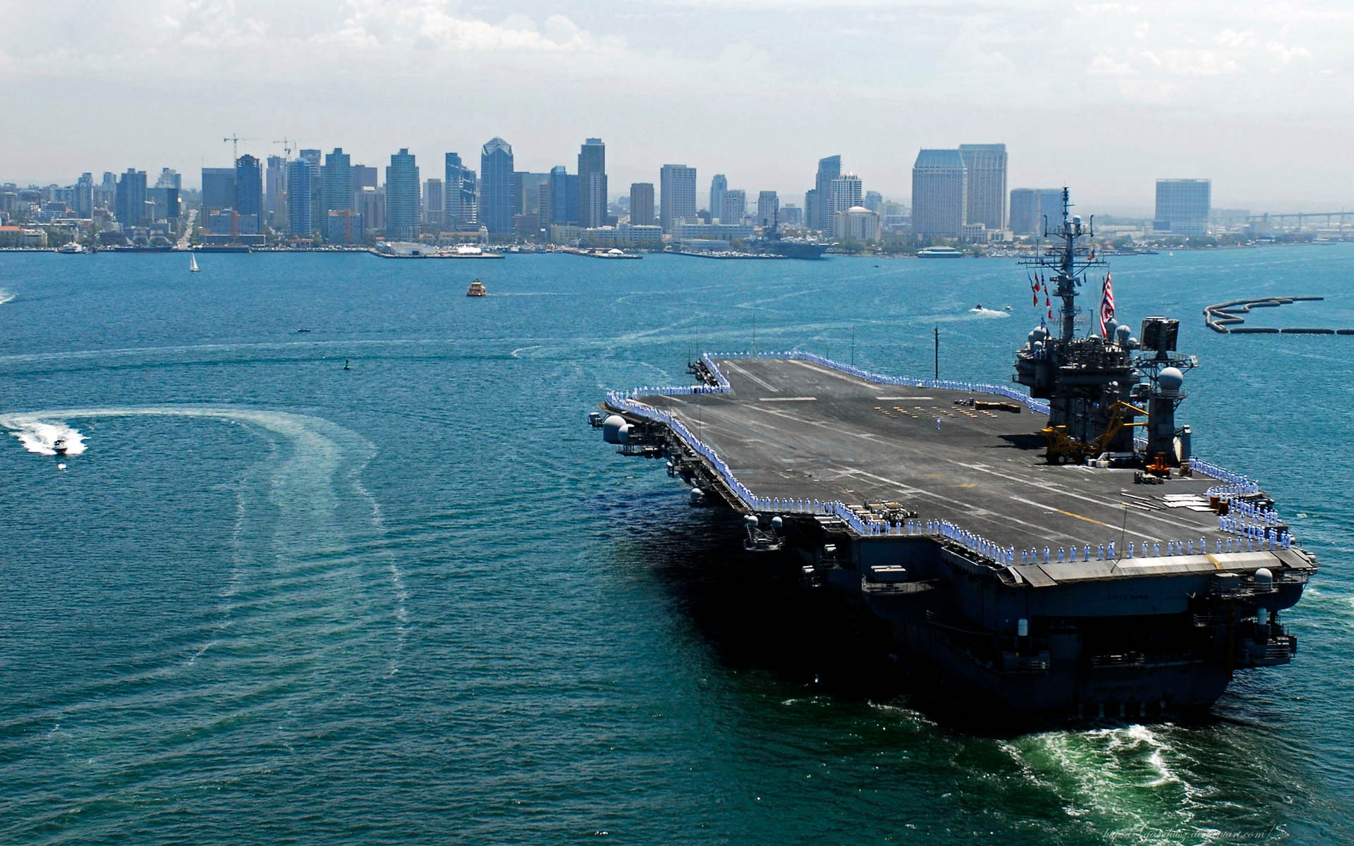 USS Kitty Hawk aircraft carrier sailing through the ocean on a clear day.
