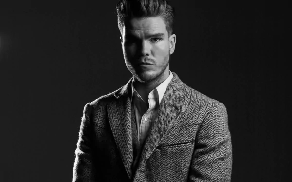 A striking black-and-white portrait of Jökull Júlíusson from the band KALEO, showcasing his confident expression and stylish attire, serves as an impressive HD desktop wallpaper.