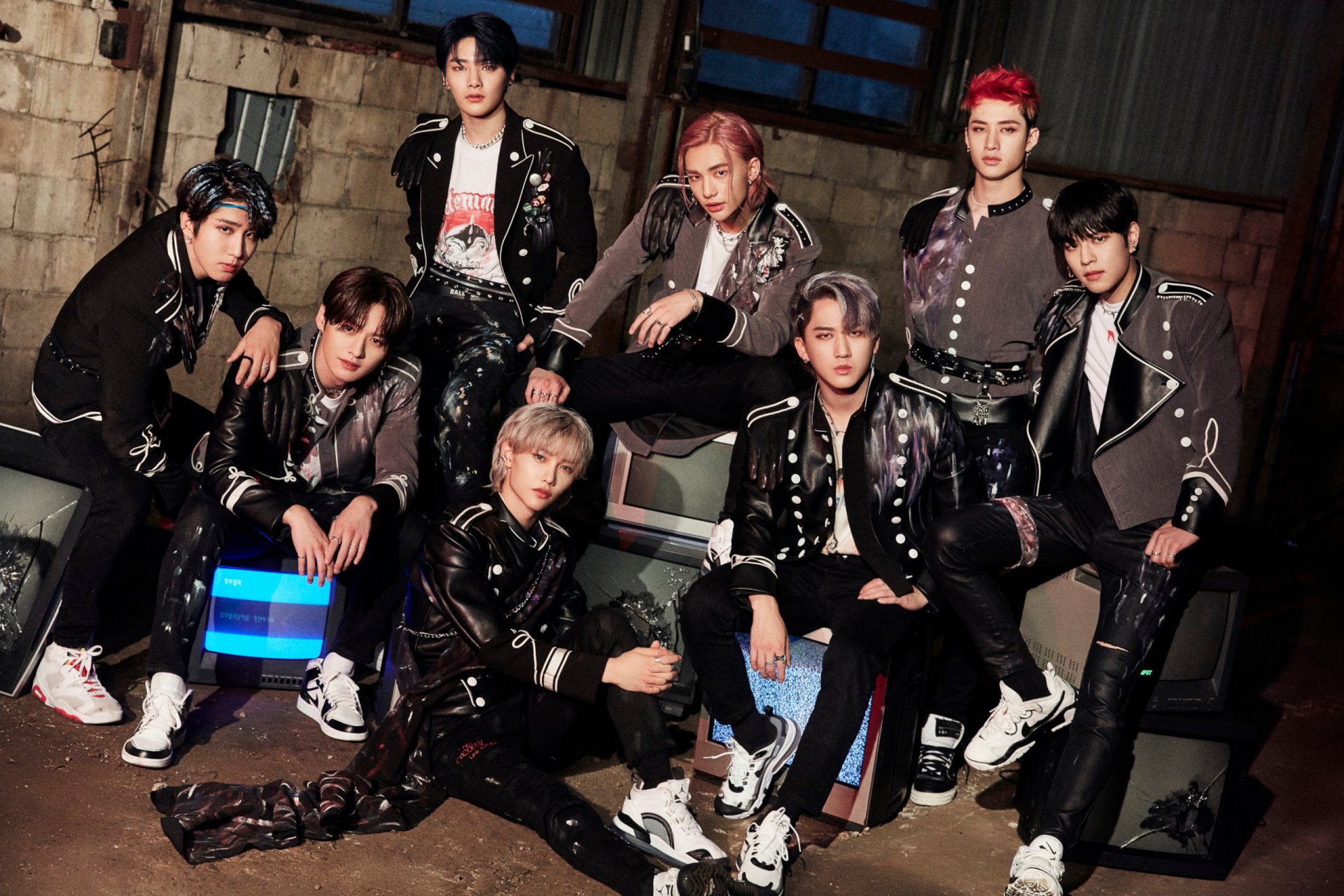 HD PC desktop wallpaper featuring Stray Kids, a K-pop boy band, posing together in stylish outfits against an industrial backdrop.