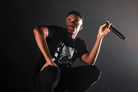 Vince Staples performs passionately on stage, captured in a dynamic pose. This HD desktop wallpaper brings the energy of music to your background.