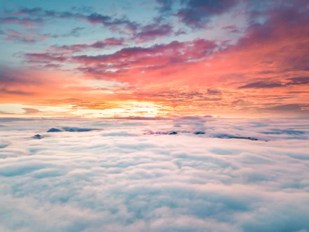 A breathtaking sunrise over a sea of clouds, highlighting vibrant hues in the sky. This stunning nature scene makes a striking 4K Ultra HD desktop wallpaper.