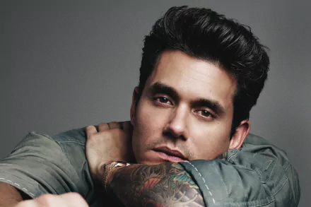 HD desktop wallpaper featuring a portrait of a man with tattoos, posing with a thoughtful expression.