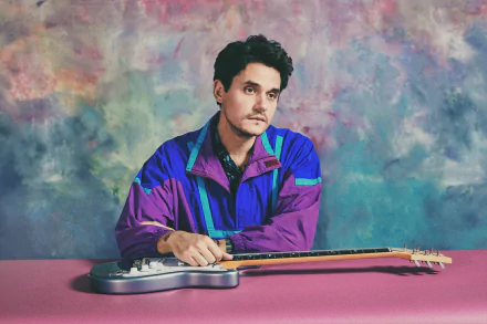 HD desktop wallpaper featuring a musician with a guitar on a colorful abstract background.