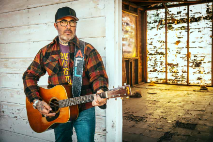 Aaron Lewis playing guitar in a rustic setting, a vibrant HD desktop wallpaper.