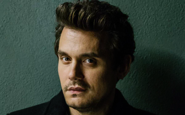 HD desktop wallpaper featuring a close-up portrait of a contemplative man with styled hair, wearing a dark jacket against a textured backdrop.