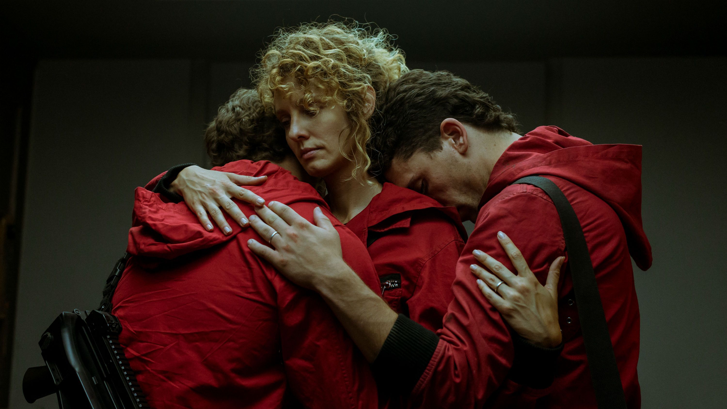 Alt Text: HD Money Heist wallpaper featuring an emotional group hug between key characters in red jumpsuits.