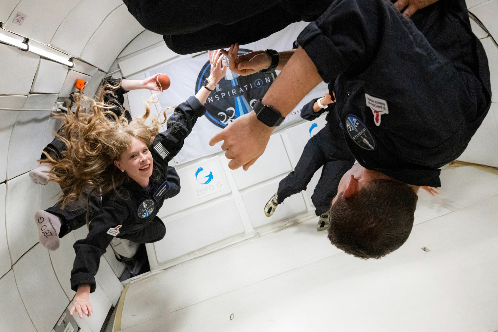 HD wallpaper featuring Inspiration4 crew members experiencing weightlessness in a simulated zero-gravity environment.