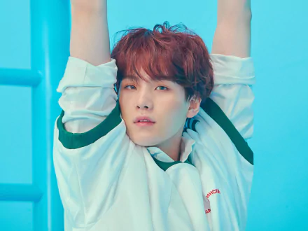 4K Ultra HD wallpaper featuring Suga (Min Yoongi) of BTS, a K-pop singer, in a relaxed pose against a vibrant blue background.