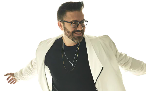 Stylish man in glasses posing with white blazer over black shirt for a HD desktop wallpaper background.