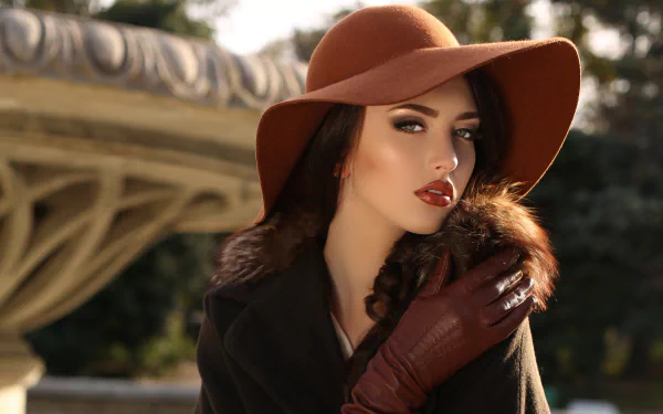 4K Ultra HD wallpaper featuring a woman model wearing a wide-brimmed hat and lipstick, dressed in dark clothing and gloves against an outdoor backdrop.
