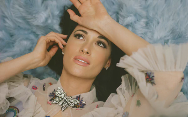 Elegantly dressed woman lying on a blue fluffy background, posing thoughtfully for an artistic HD desktop wallpaper.