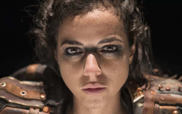 HD desktop wallpaper featuring a close-up of a determined individual with intense gaze, wearing armor-like attire.