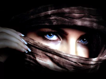 HD desktop wallpaper of a woman with striking blue eyes, partially covered by a brown cloth, providing a captivating and mysterious background.