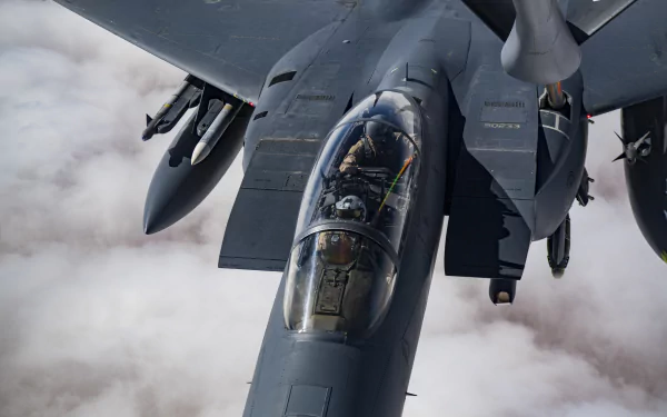 Military McDonnell Douglas F-15 Eagle cockpit close-up in flight above clouds, 5K Ultra HD PC desktop wallpaper and background.