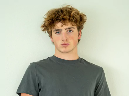 HD PC desktop wallpaper featuring Benson Boone against a plain white background, capturing his casual style and natural expression related to music.