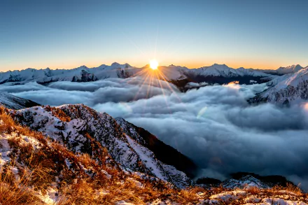 5K Ultra HD PC desktop wallpaper: sunrise over snow‑capped mountains rising above a vast sea of clouds, a serene nature mountain panorama.
