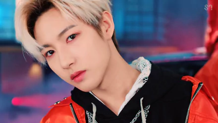 HD PC wallpaper — close-up of a blond-haired K-pop performer in a red jacket against neon blue-pink lights; music-themed NCT desktop background.