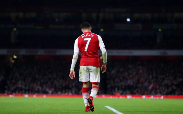 HD PC desktop wallpaper featuring footballer Alexis Sánchez wearing a red and white sports jersey with number 7, walking on a stadium field.