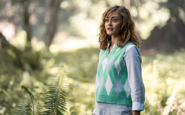 Sunlit forest portrait of a woman in a green argyle vest, Yellowjackets TV show 4K PC desktop wallpaper.