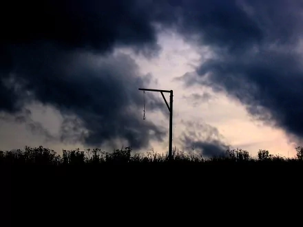 A dark night sky filled with dramatic clouds looms over a silhouetted gallows with a rope, creating a haunting and atmospheric backdrop for HD desktop wallpaper.