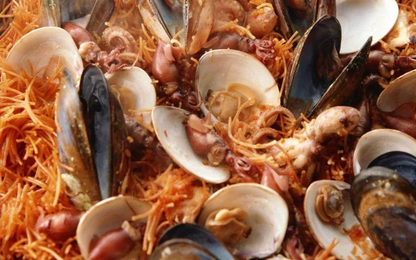 HD desktop wallpaper featuring a close-up of cooked mussels and seafood mixed with thin noodles, highlighting rich textures and vibrant colors.