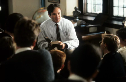 Robin Williams as John Keating in Dead Poets Society, engaging students in a classroom setting; 4K Ultra HD movie wallpaper and background.