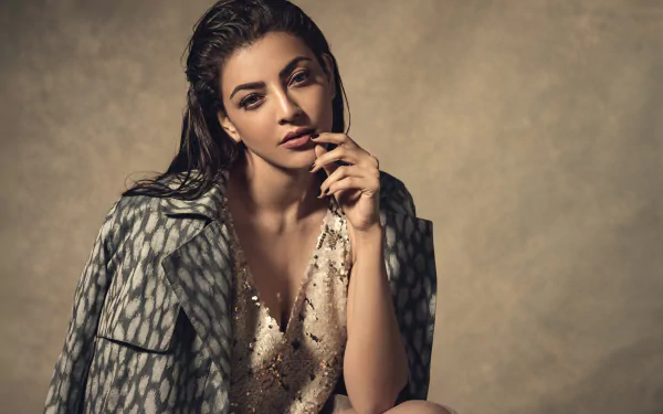 Bollywood actress Kajal Aggarwal poses confidently in a stylish outfit against a neutral backdrop in this 4K Ultra HD PC desktop wallpaper and background.